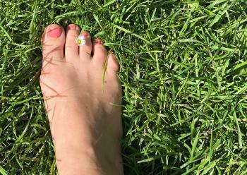 Fuß mit Blüte im Gras